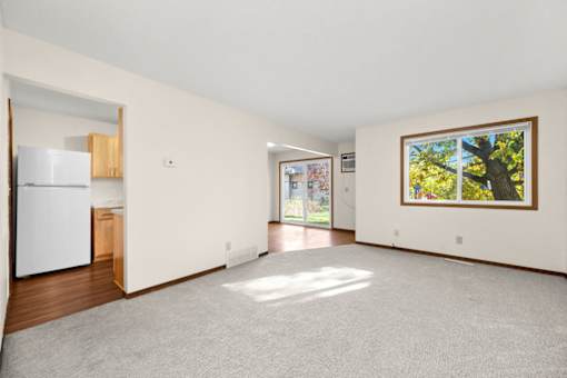 A white refrigerator is in a kitchen with wood cabinets.