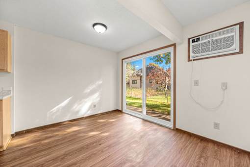 A room with a wooden floor and a window showing an outdoor view.