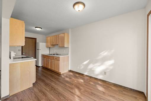 A kitchen with wooden floors and cabinets.