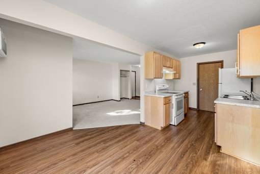 A kitchen with wooden floors and white appliances.