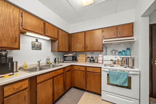 A kitchen with wooden cabinets and white appliances.