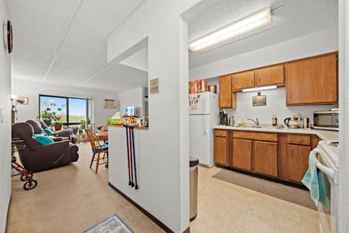 A kitchen with wooden cabinets and a refrigerator in the middle.