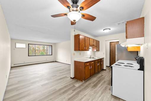 A kitchen with a white dishwasher and wooden cabinets.