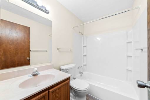 A white bathroom with a toilet, sink, and bathtub.