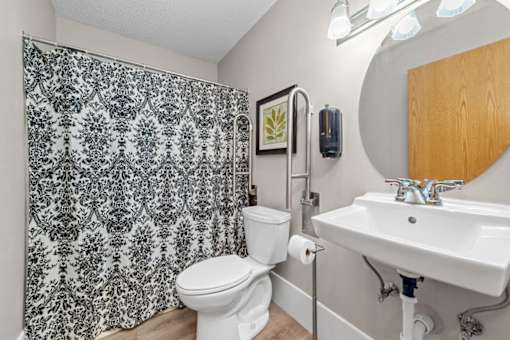 A bathroom with a toilet, sink, and shower curtain.