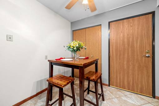A dining room with a wooden table and chairs.
