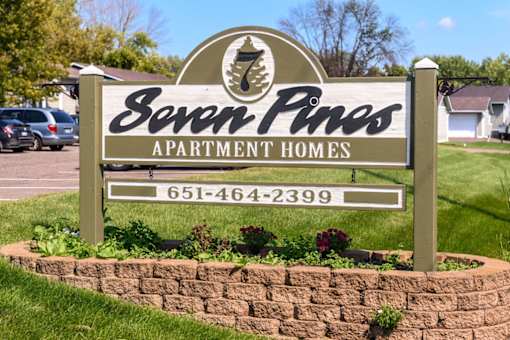A sign for Seven Pines Apartment Homes with a phone number on it.