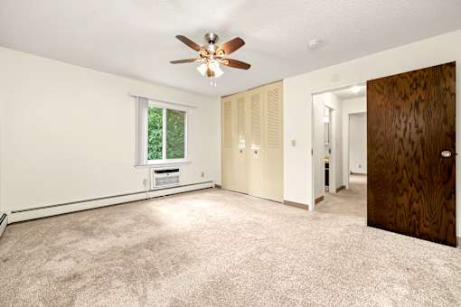 A room with a ceiling fan and a window.