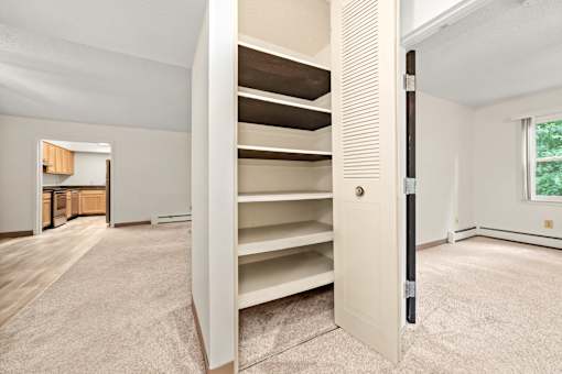 A white door with a black handle is open in a room with a carpeted floor.