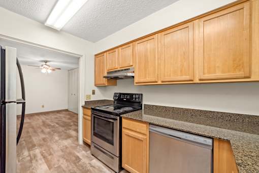 A kitchen with wooden cabinets and a black stove top oven.