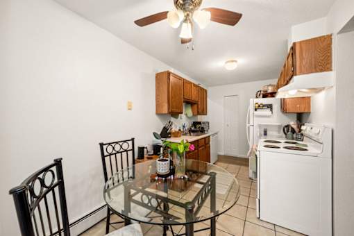 A kitchen with a table and chairs.