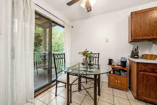 A kitchen with a table and chairs by a sliding glass door.