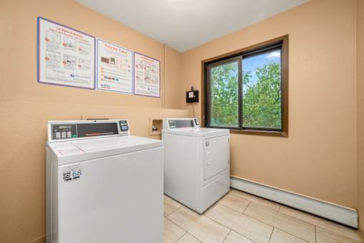A laundry room with a washer and dryer and instructions on the wall.