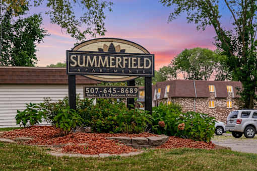 A sign for Summerfield Apartments is displayed in front of a building.