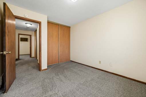 A room with a carpeted floor and a doorway leading to another room.