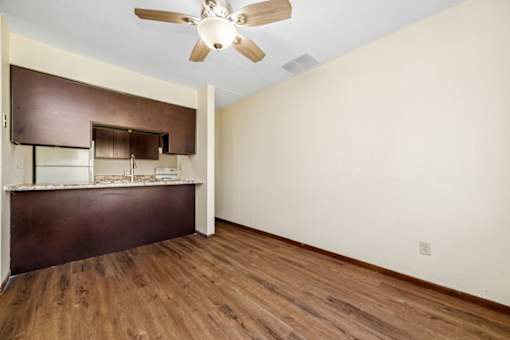 A room with a ceiling fan and wooden floors.
