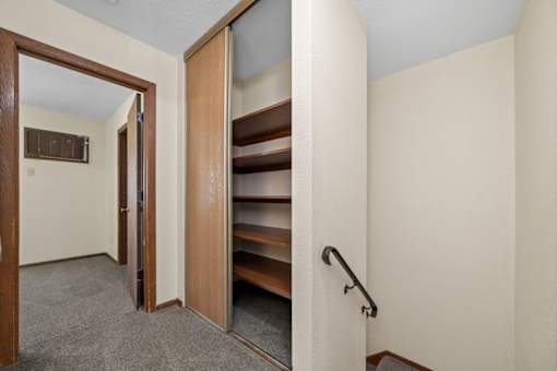 A hallway with a staircase and a door.