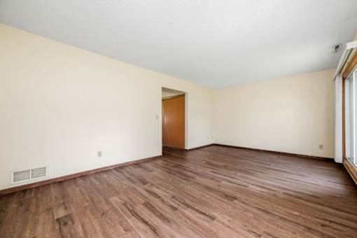 A room with wooden floors and a door.
