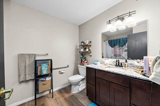 A bathroom with a toilet, sink, and mirror.