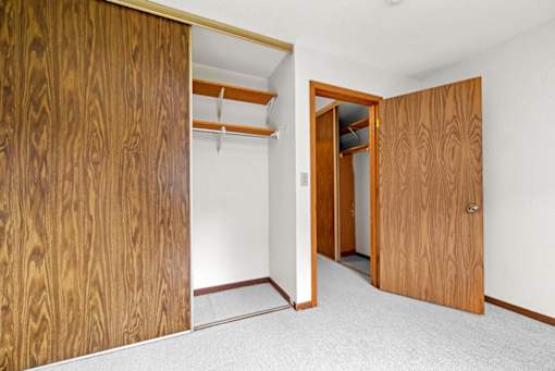 A room with a wooden door and a white wall.