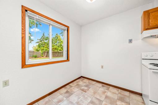 A room with a window and a tiled floor.