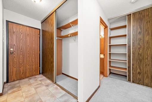 A room with a wooden door and a mirror on the wall.