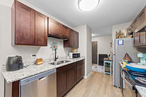 A kitchen with brown cabinets and a white counter top.