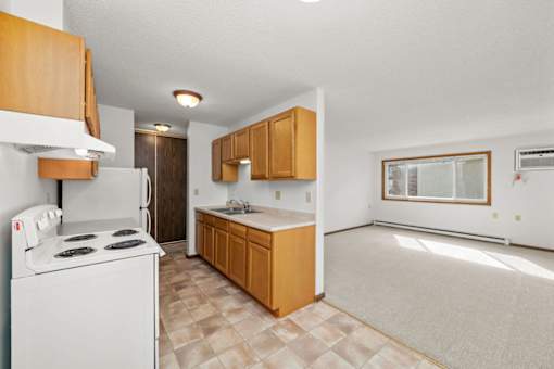 A kitchen with a white stove and wooden cabinets.