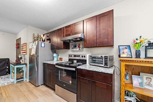 A kitchen with brown cabinets and a black stove top oven.
