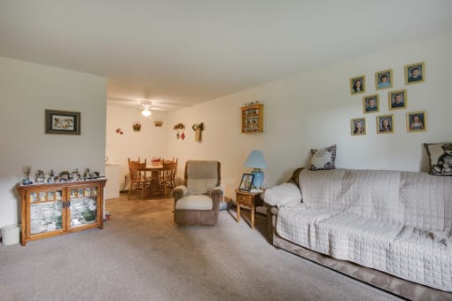a living room with a couch and a chair and a dining room table