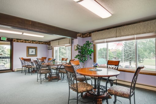 a dining room with tables and chairs and large windows