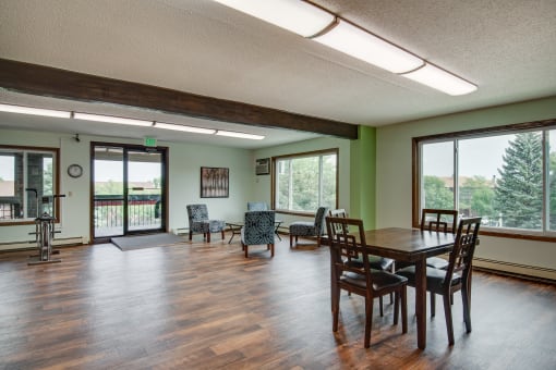 a living room with a table and chairs and a large window