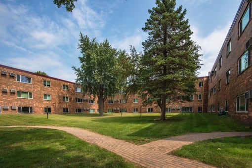 the exterior of a brick building with grass and trees
