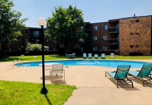 a swimming pool with two chairs and a lamp