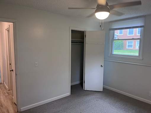 A room with a ceiling fan and a window.