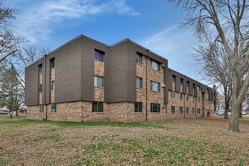 the exterior of a brick building with a blue sky in the background