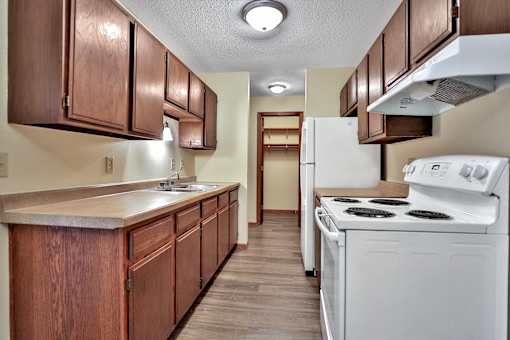 a kitchen with white appliances and wooden cabinets