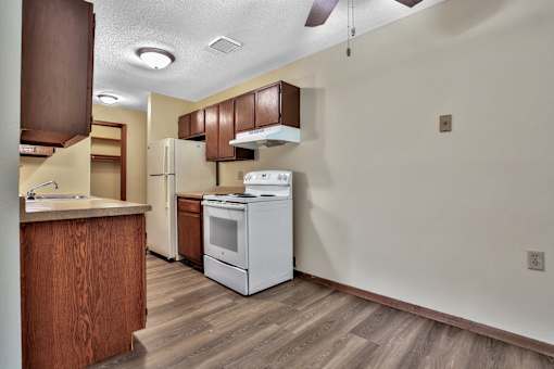 an empty kitchen with a stove refrigerator and sink