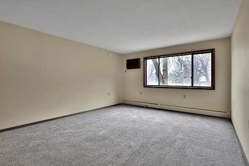 the living room of an empty house with a large window