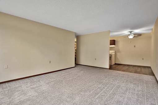 the living room and kitchen of an empty apartment