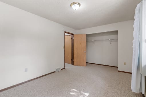 an empty living room with a door to a closet