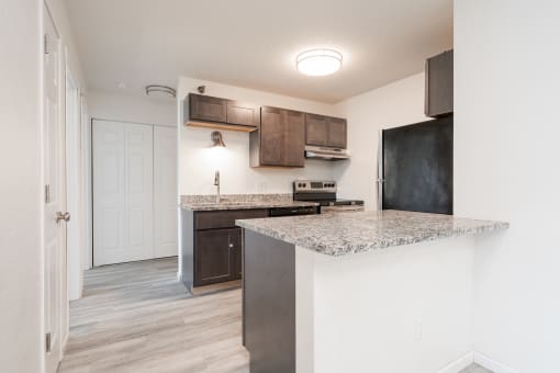 a kitchen with a marble counter top and a refrigerator