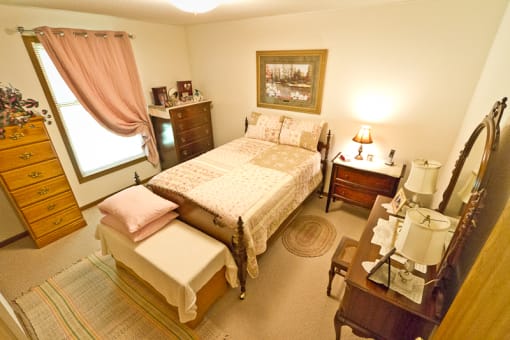 a bedroom with a bed and a dresser and a mirror