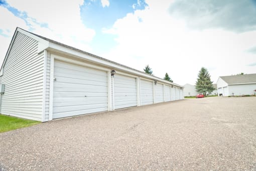 a row of white garage doors on the side of a building