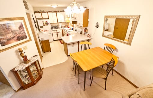 a dining room and kitchen with a wooden table and chairs