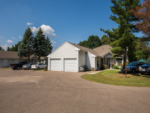 a white house with a driveway and a parking lot