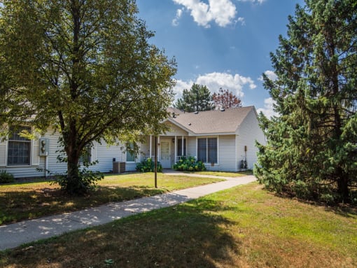 a white house with trees and a sidewalk