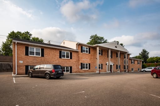 a large brick building with a car parked in a parking lot
