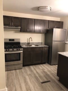 a kitchen with stainless steel appliances and wooden floors