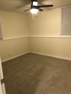 an empty room with a ceiling fan in it